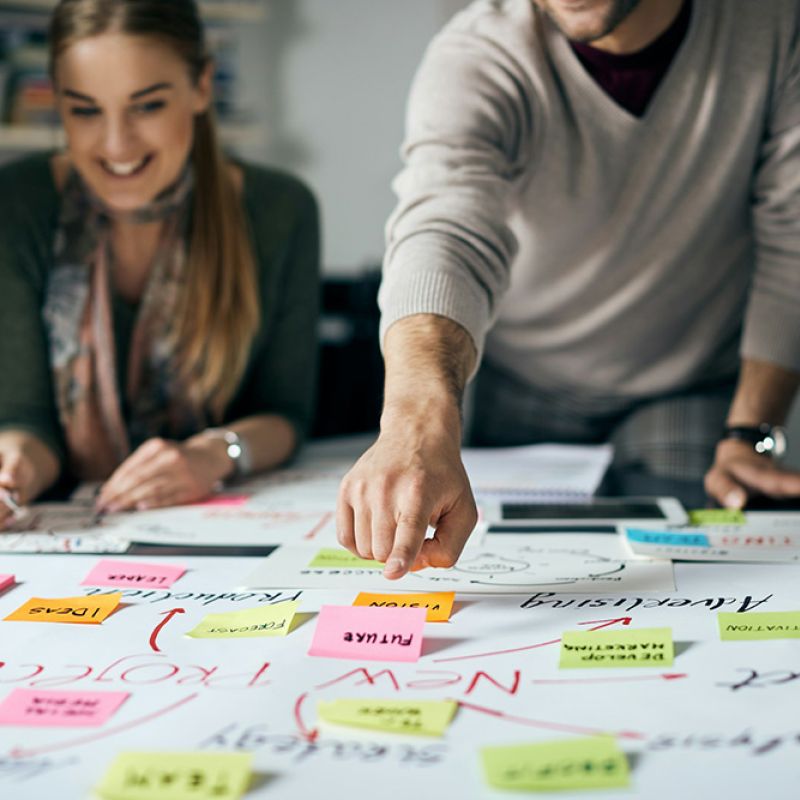 Team arbeitet fokussiert mit bunten Notizen – Sinnbild für Analyse, Klarheit und das Erkennen individueller Potenziale.